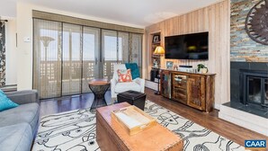 Una sala de estar con un sofá, una mesa de centro, un televisor y una chimenea.