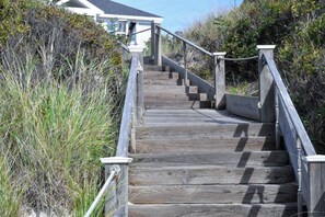 A wooden staircase leading to a house surrounded by dense vegetation. - Beachfront on Private Beach w/ AC! (Truro)