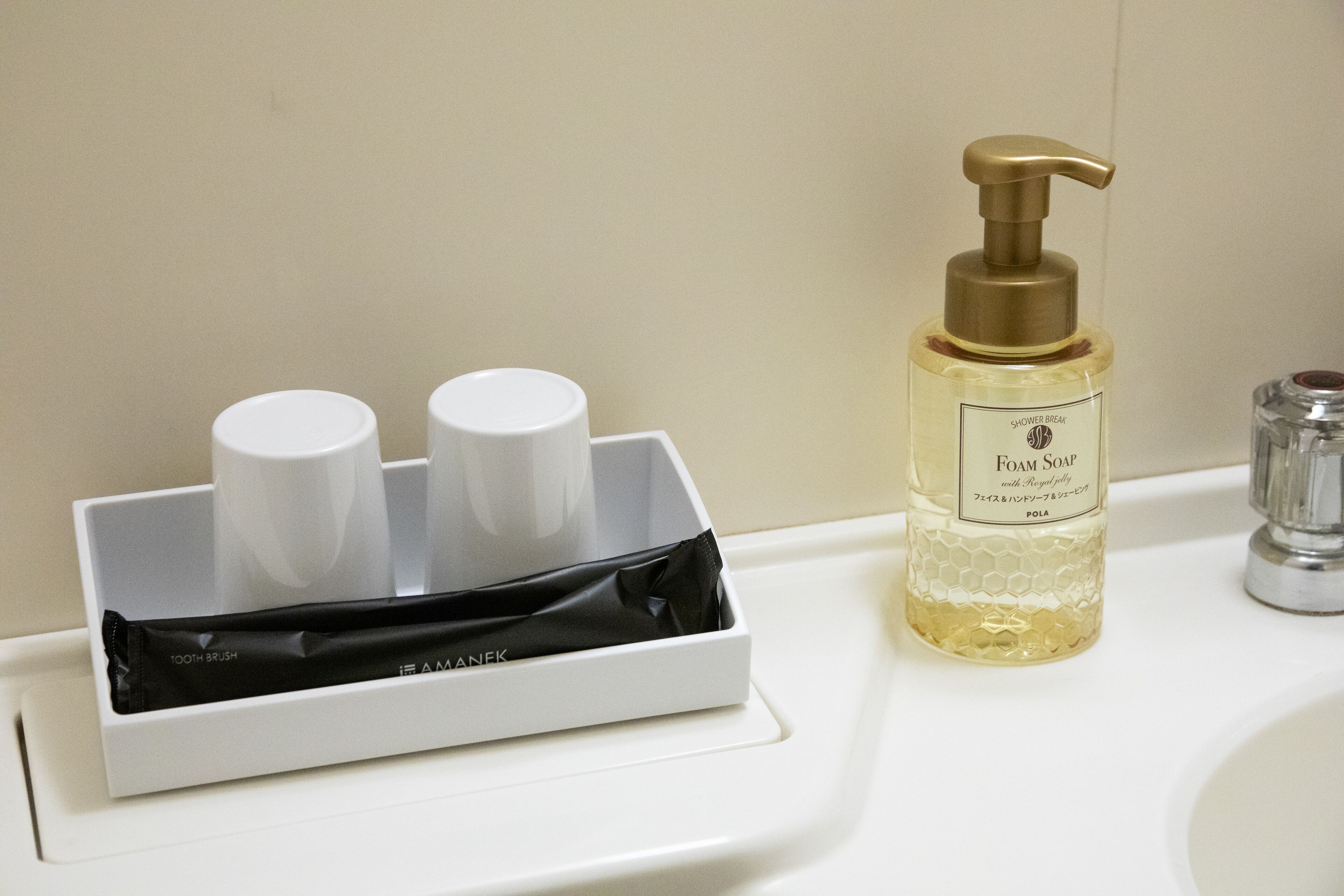 A bathroom sink with a soap dispenser and a toothbrush holder.
