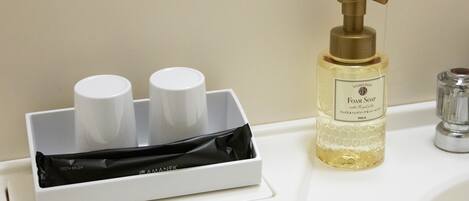 A bathroom sink with a soap dispenser and a toothbrush holder.