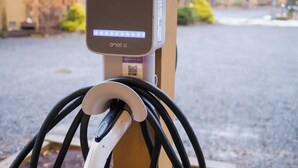 Eine JuiceBox Ladestation, die an einem Holzpfosten befestigt ist.