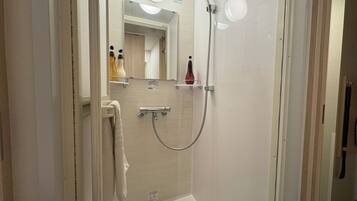 A modern bathroom with a shower, a towel rack, and a mirror.