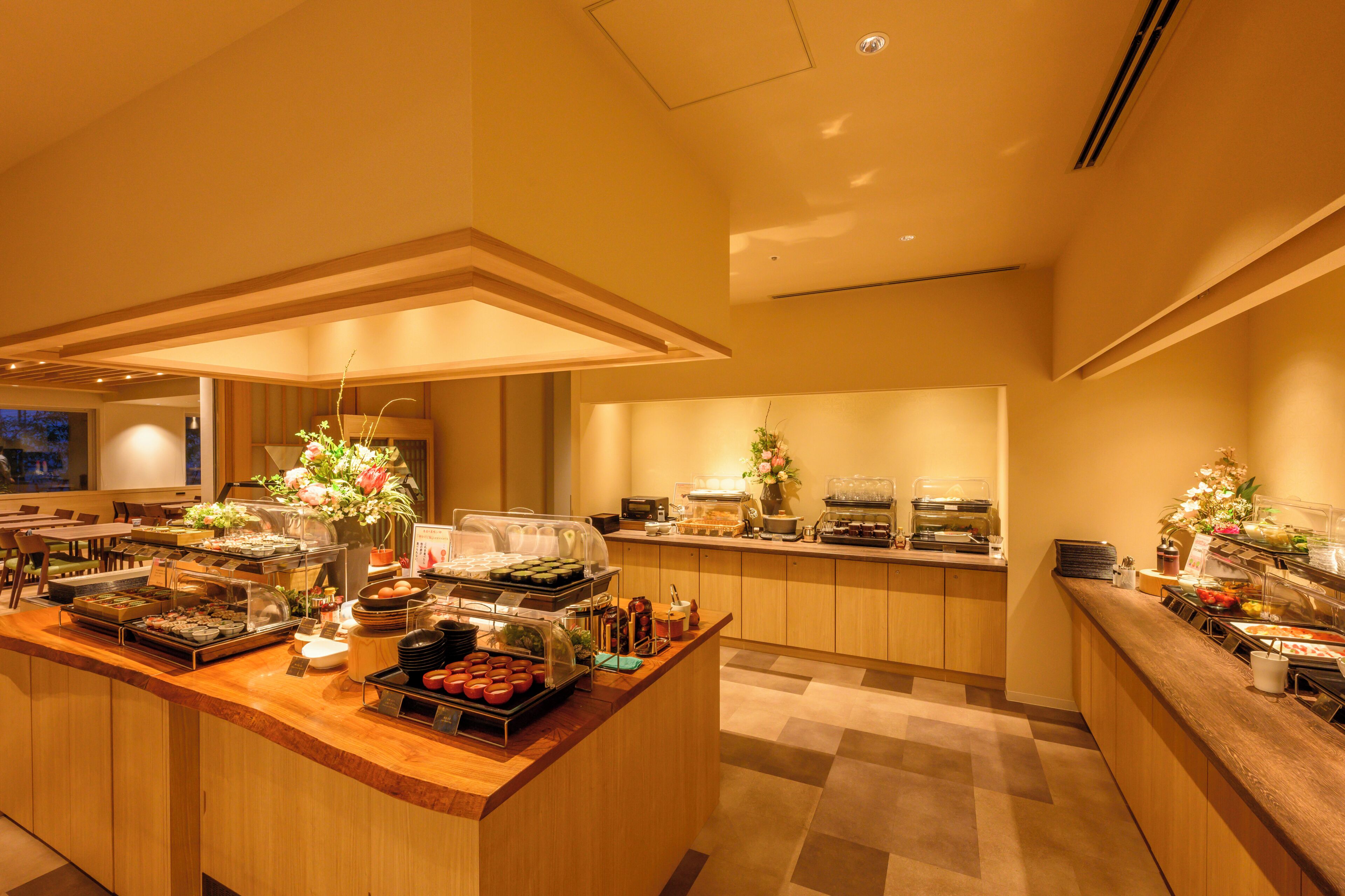 A buffet area with various food stations, a central serving counter, and a decorative floral arrangement.