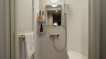A small, enclosed bathroom with a shower, a toilet, and a mirror. There is a towel rack with a towel hanging on it.