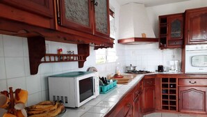 Une cuisine avec des meubles en bois, un four à micro-ondes et une cuisinière.