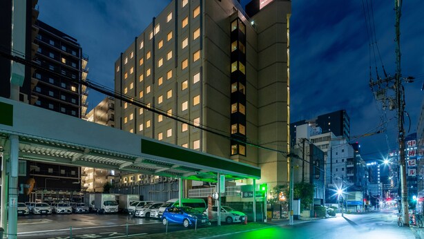 A hotel with multiple floors, a gas station, and parked cars. - The OneFive Osaka Sakaisuji (Osaka)