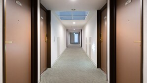 A long, narrow hallway with doors on both sides, numbered 1015 and 1002, leading to rooms. - The OneFive Osaka Sakaisuji (Osaka)
