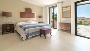 Una camera da letto con un letto, due comodini, una cassettiera e un'ampia finestra vista.