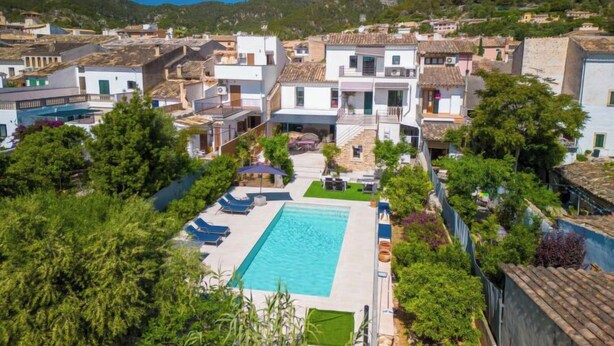 Zona residenziale con piscina circondata da vegetazione e palazzi.