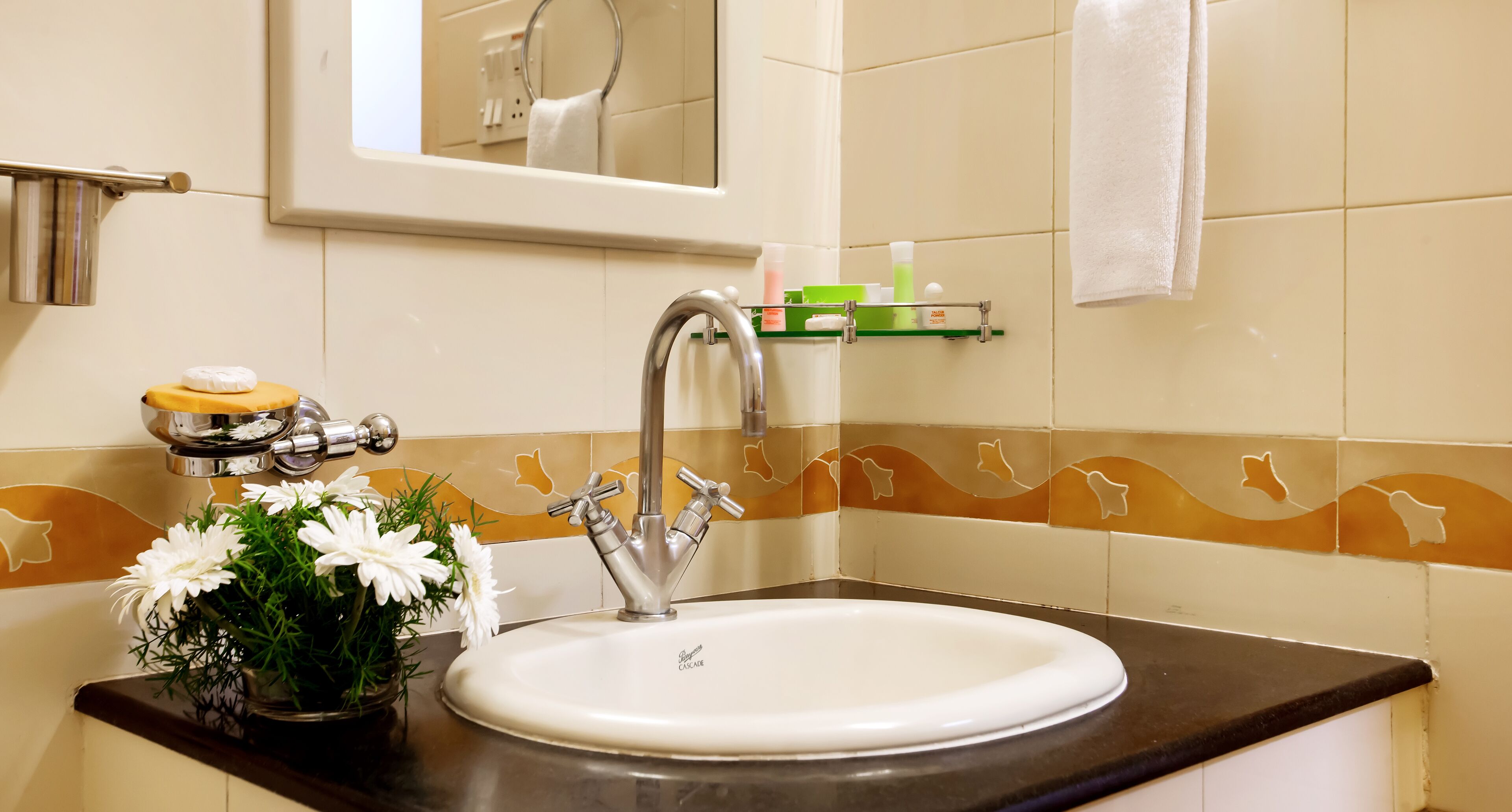 Un baño con un lavamanos blanco, un espejo encima y un perchero para toallas.