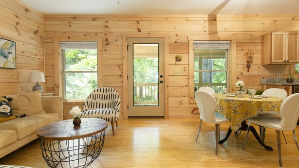 A wooden cabin interior with a dining table, chairs, a sofa, and a coffee table. - “Just BEE🐝Log Cabin"-Stunning, peaceful, NEW, -10 min to Dwtn Asheville, dogs ok (Asheville)