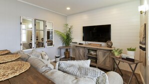 A living room with a sofa, a coffee table, a TV, and a cabinet. - Lighthouse 5-5B (Kimberling City)