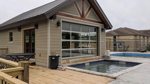 A house with a large garage door, a wooden deck, a pool, and a fenced backyard. - Lighthouse 5-5B (Kimberling City)