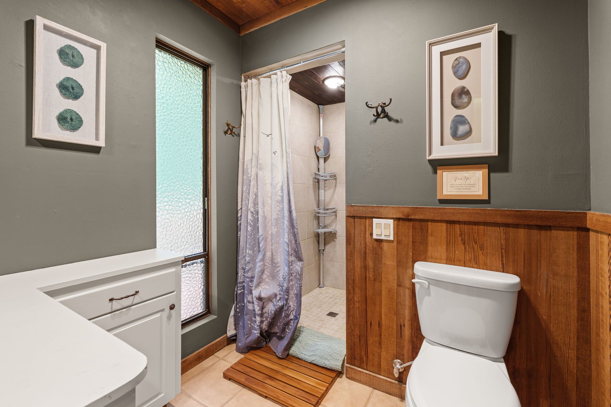 A bathroom with a shower, toilet, and sink.
