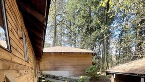 A wooden cabin with a gravel path leading to a garage.