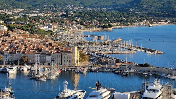 A marina with boats docked, a town in the background, and mountains in the distance. - Le Colibri dans la colline rated 3*. (La Ciotat)