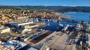 A marina with boats, a large building, and a cityscape in the background. - Le Colibri dans la colline rated 3*. (La Ciotat)