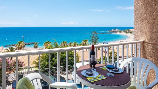 A balcony with a table set for two, overlooking a beach and the sea. - 1.1 Beautiful seafront with balcony and WIFI (Arona)