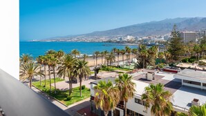 Un hotel frente al mar con vistas a la costa y montañas.