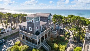 A multi-story beachfront property with a prominent upper level featuring large windows and a balcony. - Wonderful Coastal Retreat, Open Layout, Steps Away From Beach, Fireplace, BBQ, Ocean Views (Depoe Bay)
