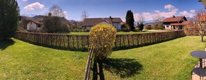 Experience the tranquility of a serene residential setting with a beautifully maintained lawn and picturesque views of the surrounding mountains.