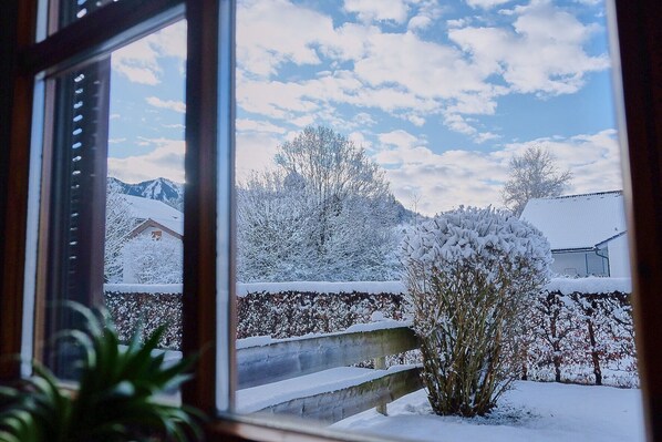 Guests can enjoy a serene winter view from the comfort of their room, with a snow-covered landscape and distant building visible through the window.