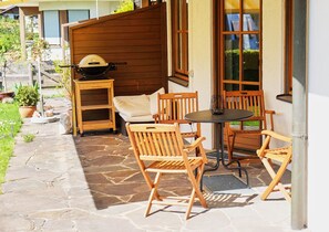 Relax on the patio with a view, surrounded by lush greenery and comfortable seating.
