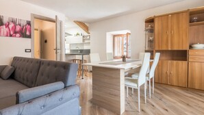 Una cocina moderna con comedor, sofá y armarios de madera.