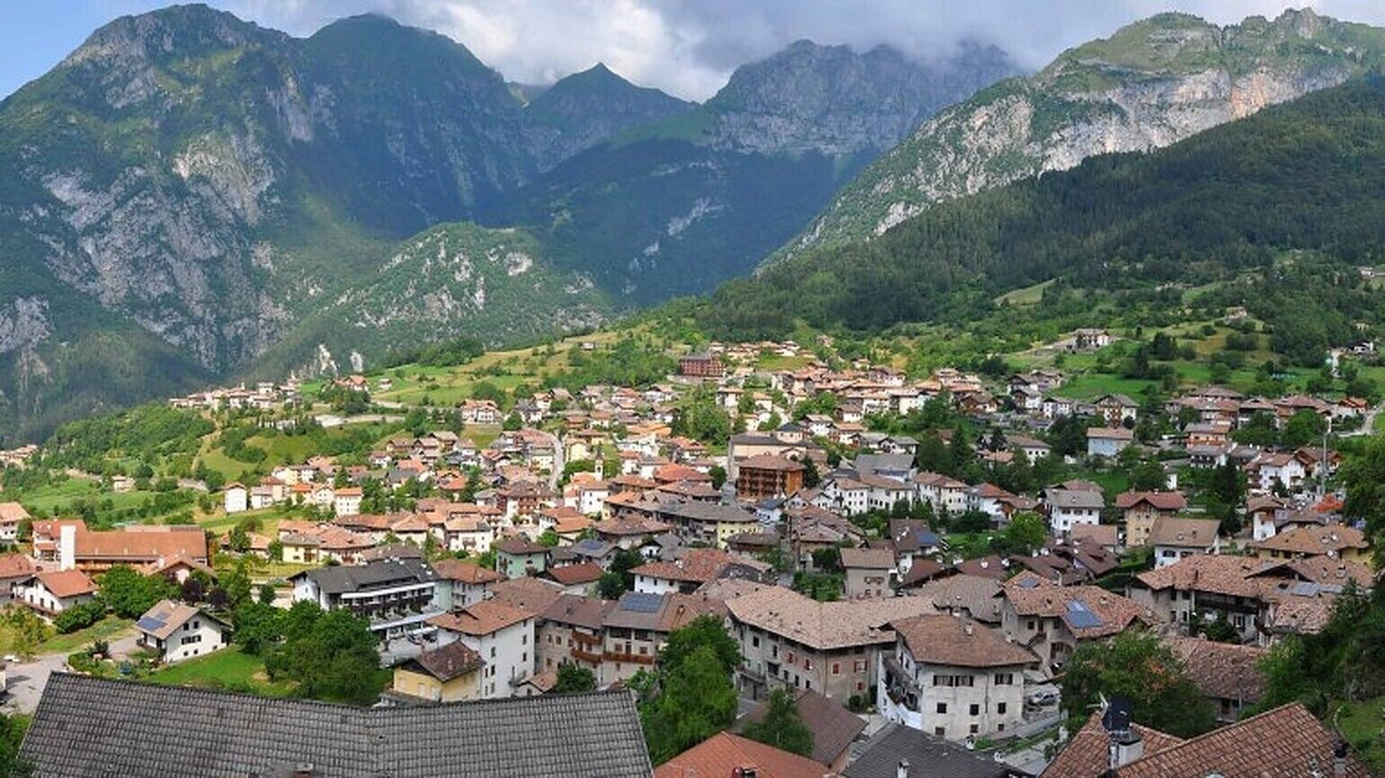 Un pueblo montañoso con arquitectura tradicional, campos en terrazas y un denso conjunto de edificaciones.