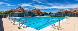 Une piscine avec plusieurs couloirs, un vestiaire et une vue sur des montagnes de grès rouge.