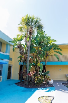 Outdoor pool, open 9:00 AM to 9:00 PM, pool umbrellas, sun loungers at Garnet Inn & Suites, Orlando