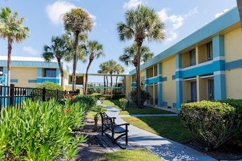 Outdoor pool, open 9:00 AM to 9:00 PM, pool umbrellas, sun loungers at Garnet Inn & Suites, Orlando