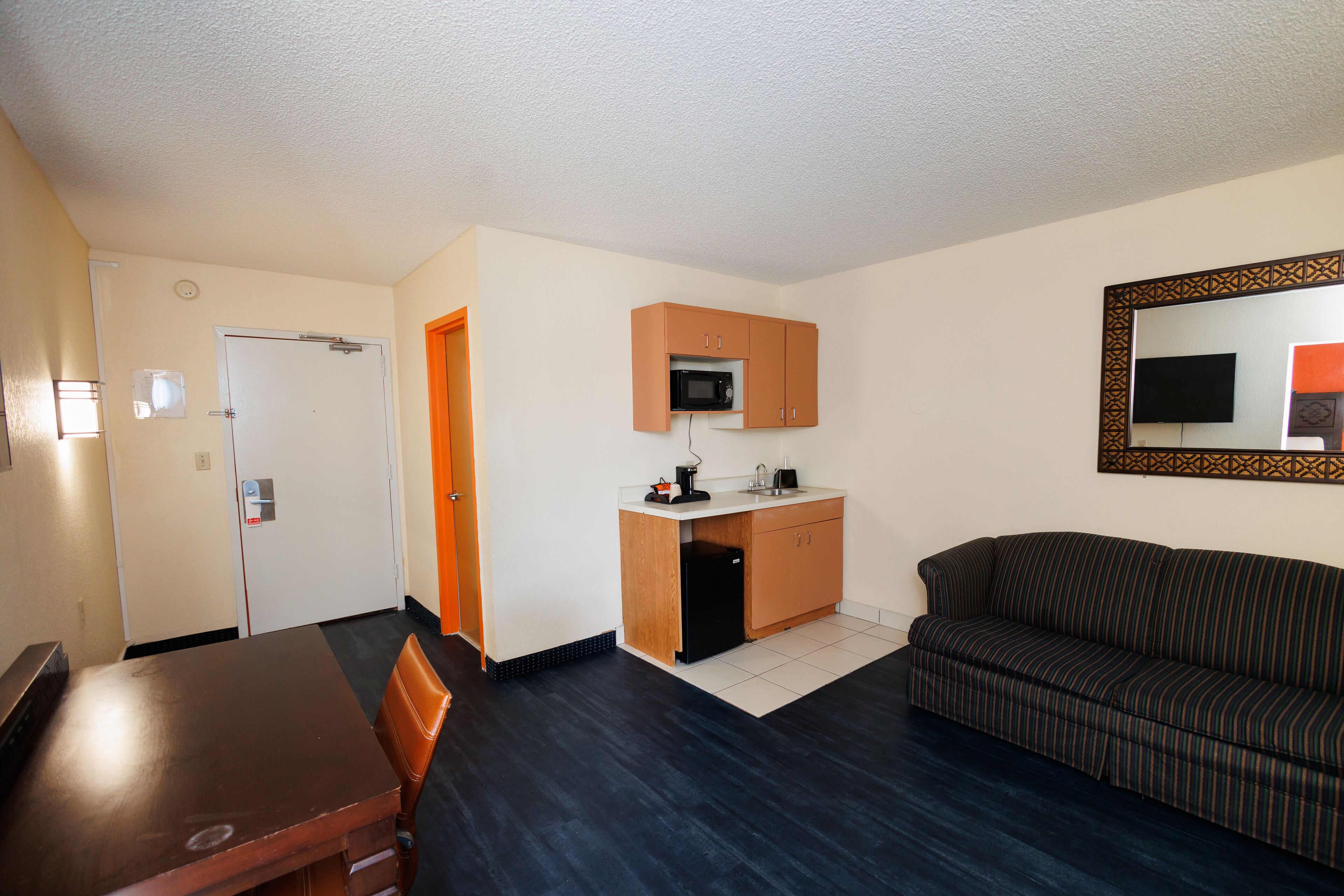 A compact living space with a kitchenette, a dining area, and a sofa.