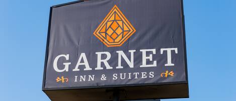 Letrero del Garnet Inn & Suites con un logotipo en forma de diamante.