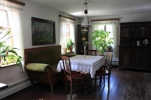Ein Esszimmer mit Tisch, Stühlen, einer Couch und einem Schrank.