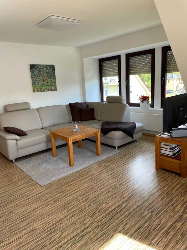 A modern living room with a sofa, a coffee table, and a TV stand. - Hänsel Vacation Rental, Germany (Zinnowitz)