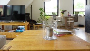 A modern living room with a television, a glass table, and a plant. - FeWo Hänsel, Germany (Zinnowitz)
