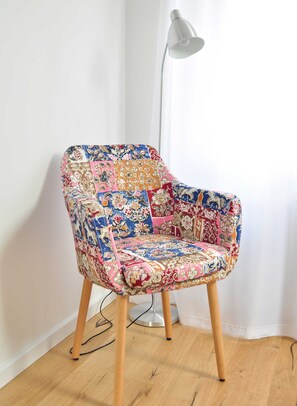 A colorful armchair with a patchwork design, a modern floor lamp, and a wooden floor. - FeWo Hänsel, Germany (Zinnowitz)