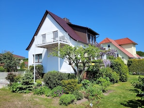 A two-story house with a balcony, surrounded by a well-maintained garden. - Hänsel Vacation Rental, Germany (Zinnowitz)