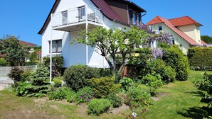 A two-story house with a balcony, surrounded by a well-maintained garden. - FeWo Hänsel, Germany (Zinnowitz)