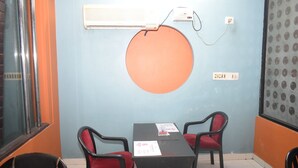 Una sala de conferencias con una mesa y dos sillas, un equipo de aire acondicionado y una pared con un diseño circular.