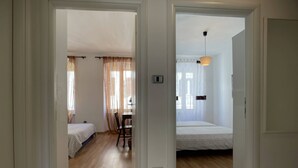 A room with a bed, a desk, and a chair. There is a window with curtains and a door leading to another room. - Apartment Igor is located in Pula, 100 m from the Pula Arena. (Pula)