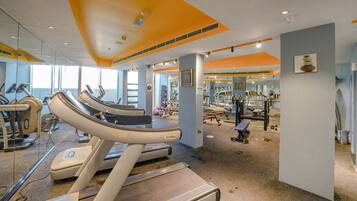Ein Fitnessstudio mit Laufbändern, Kraftgeräten und Spiegeln.
