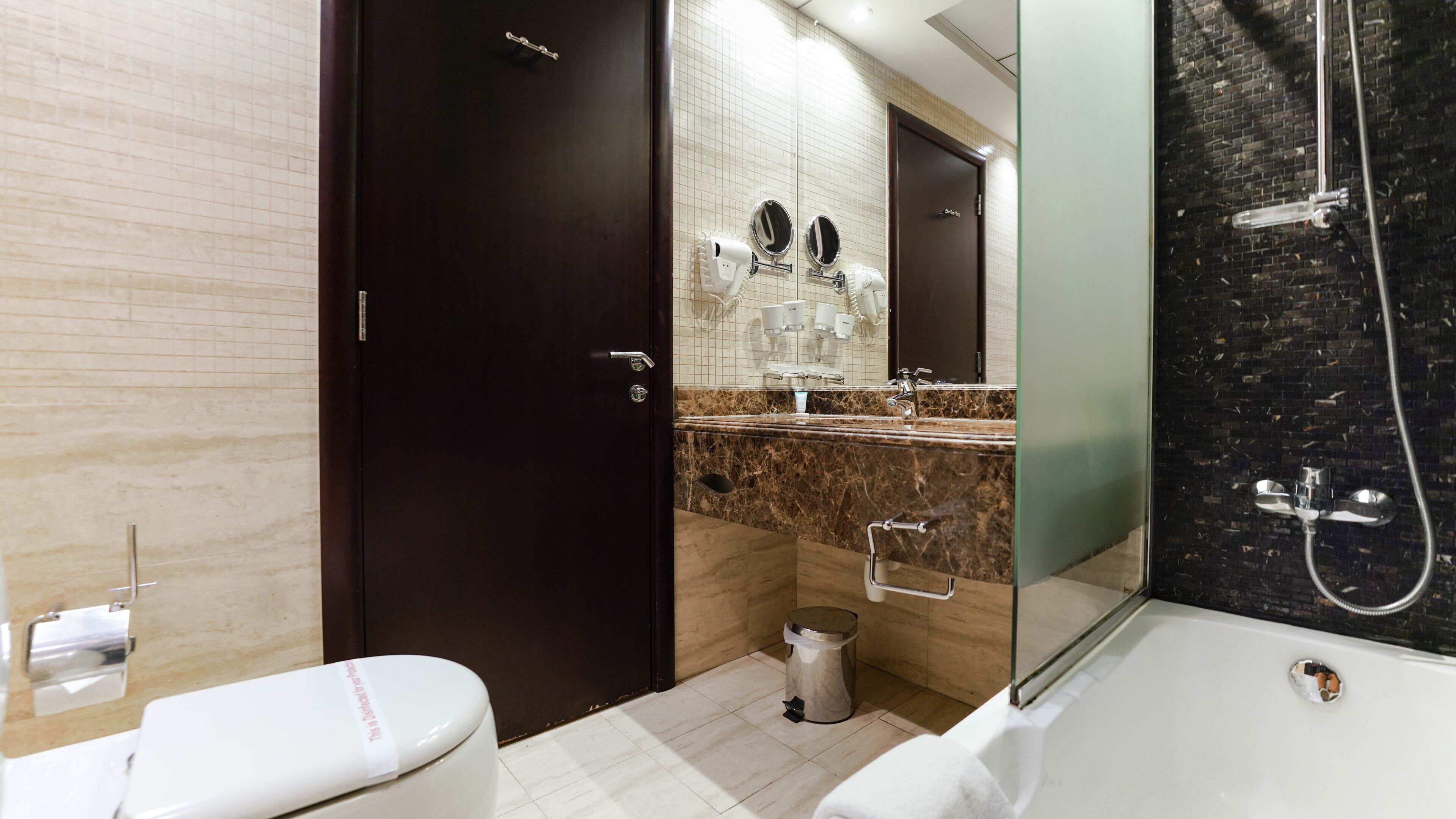 A modern bathroom with a toilet, sink, and shower.