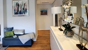 A modern living room with a sofa, a coffee table, a lamp, and a decorative mirror. - Paradise Apartment by LovelyStay (Funchal)