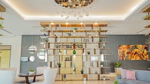 Un interior moderno con una estantería central, un sofá y una zona de comedor.