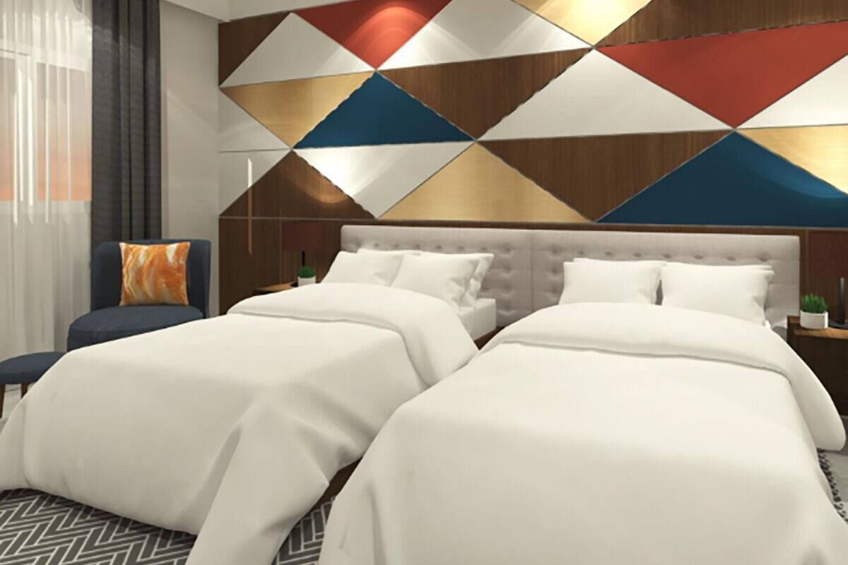 A hotel room with a large bed, a chair, and a decorative wall panel.