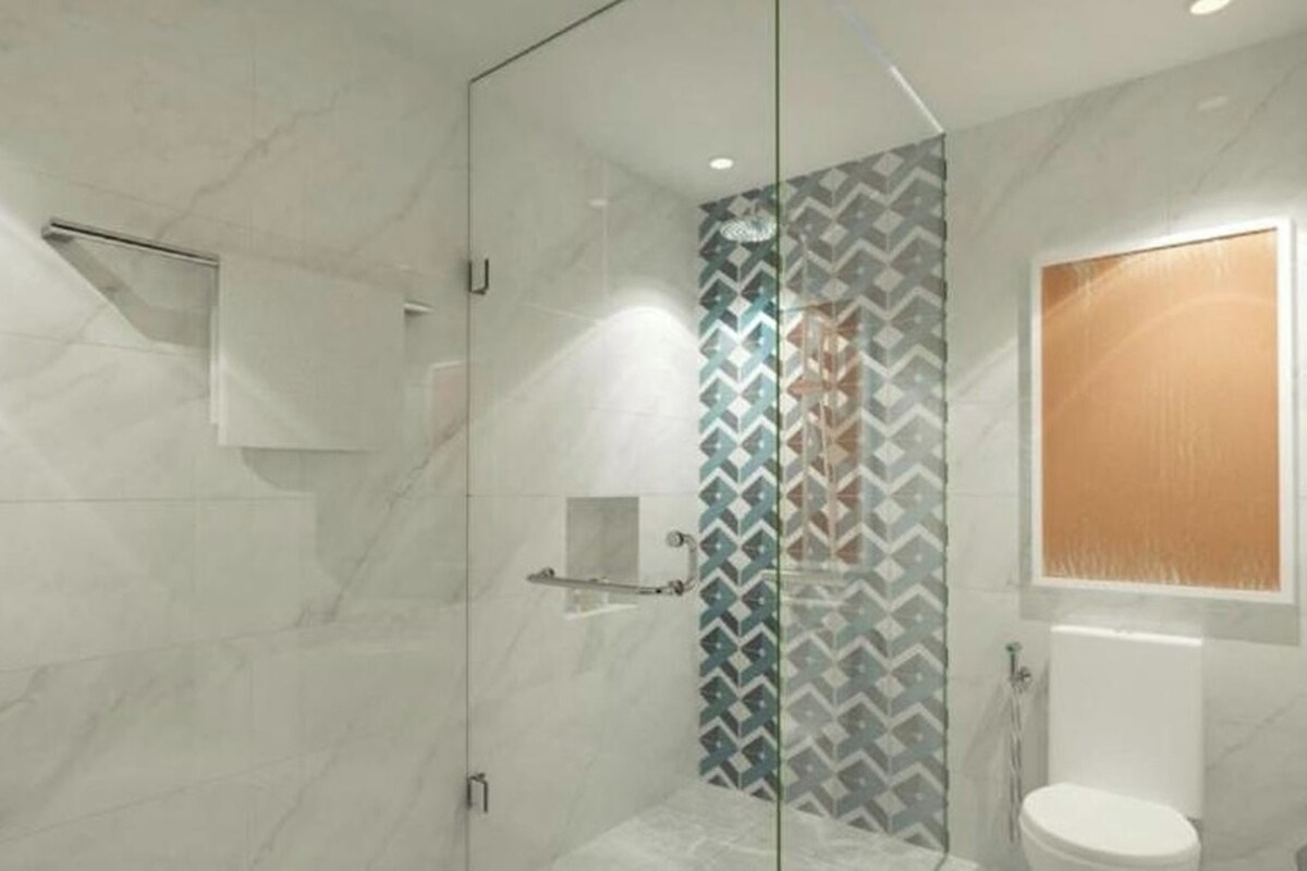 Un baño moderno con cabina de ducha de vidrio, inodoro y barra para toallas.