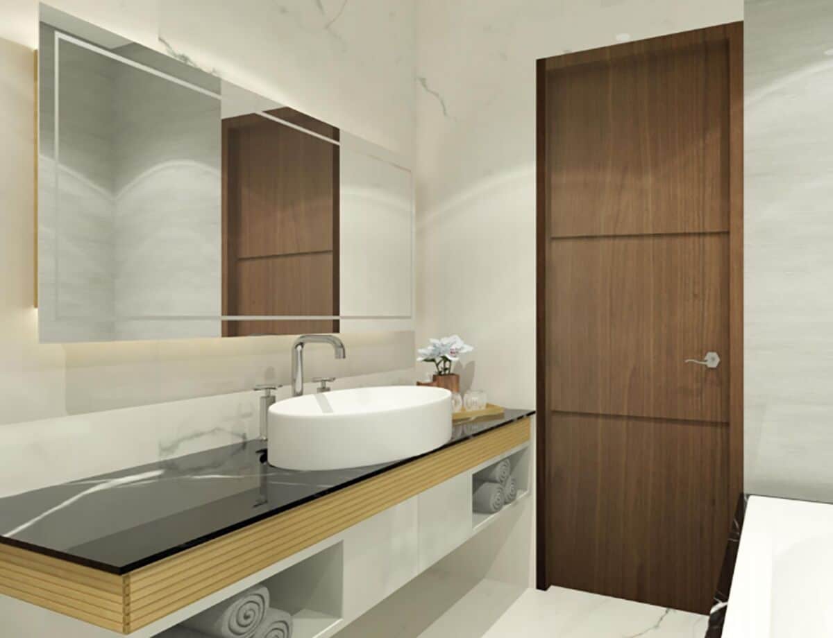 Un baño moderno con un espejo grande, un lavamanos redondo, armarios de madera y una puerta de madera.