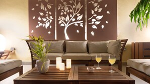 Ein gemütlicher Sitzbereich mit einer Couch, zwei Holztischen und einem Blumentopf.